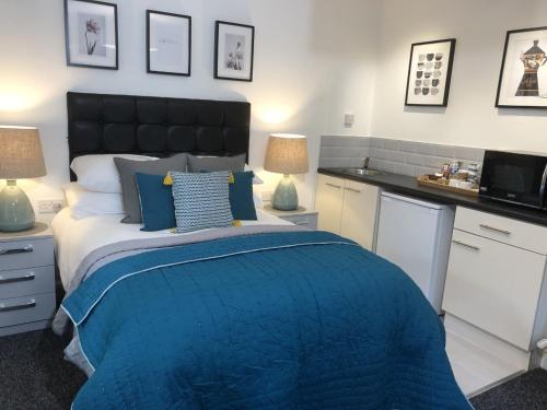 a bedroom with a bed with a blue comforter at Anson Studios Walsall M6, J10 in Walsall