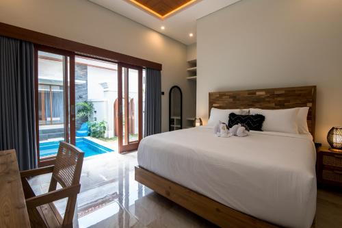 Un dormitorio con una cama con dos animales de peluche encima. en Villa Sakura III Seminyak, en Seminyak