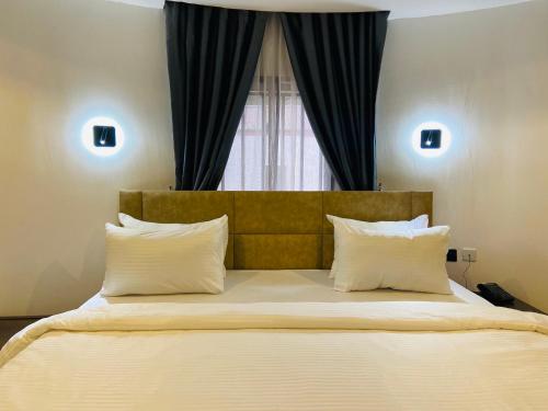 ein Schlafzimmer mit einem großen Bett mit Fenster in der Unterkunft GrandServe Luxury in Abuja