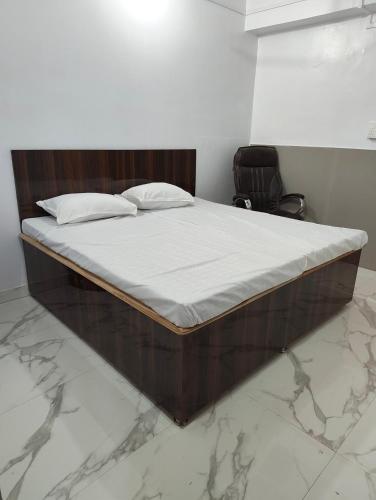 a large bed in a room with marble floors at D'Yogi Rooms & Dormitory in Varanasi
