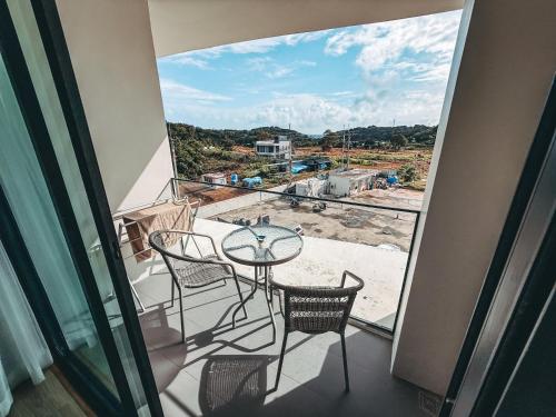 un balcon avec une table et des chaises et une vue dans l'établissement FAMILY HOMES Wyndham - Spacious 2BDRM Just Steps from Rawai Beach, à Ban Saiyuan (1)