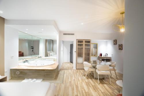 a bathroom with a tub and a table and chairs at Hotel Donia Sfax in Sfax