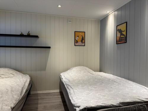 a bedroom with two beds and two pictures on the wall at Apartment in Tromsø in Tromsø