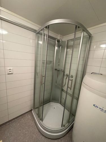 a shower with a glass door next to a toilet at Apartment in Tromsø in Tromsø