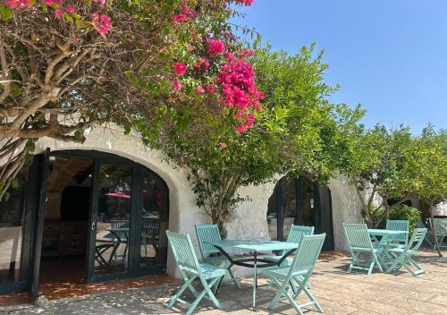 a group of chairs and a table with pink flowers at Agroturismo Matxani Gran in Sant Climent