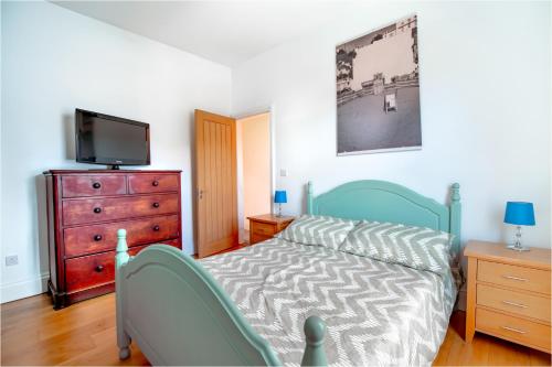 a bedroom with a bed and a dresser and a tv at Perfect Booking Near Ramsgate Station And Beach in Ramsgate
