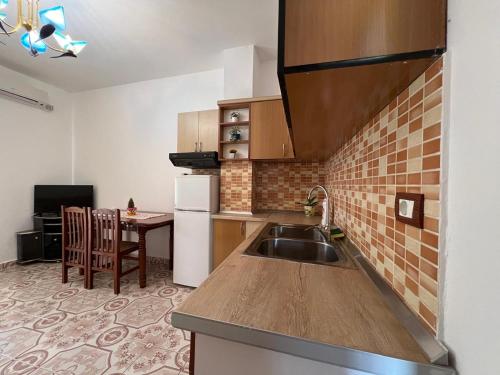 a small kitchen with a sink and a table at Kevi City Center Apartments in Përmet