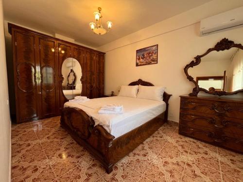 a bedroom with a large bed and a dresser at Kevi City Center Apartments in Përmet