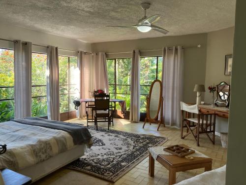 a bedroom with a bed and a table and chairs at Cycasia Lodge in Umzumbe