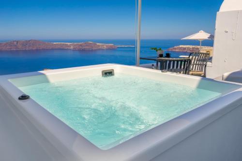 a jacuzzi tub with a view of the ocean at Sunset Caldera Seaview Houses in Imerovigli