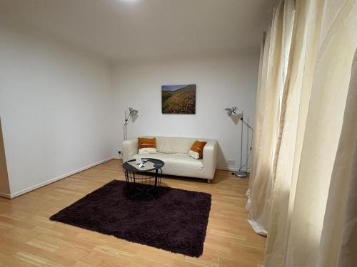 a living room with a white couch and a table at Misk Homes #3 Near Heathrow Airport, shops & Brunel University - Free Parking in Uxbridge