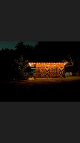 a barn with lights on it at night at Langaland Glamping in Susenii Bîrgăului