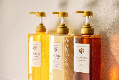 three bottles of soap sitting next to a wall at 又楽坊 Matarakubou in Fujiyoshida