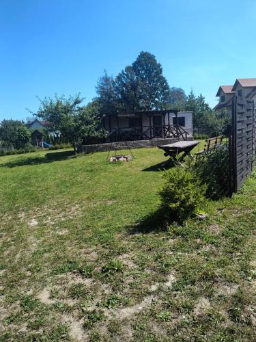 a yard with a picnic table and a house at Leśna Aura in Ponizie