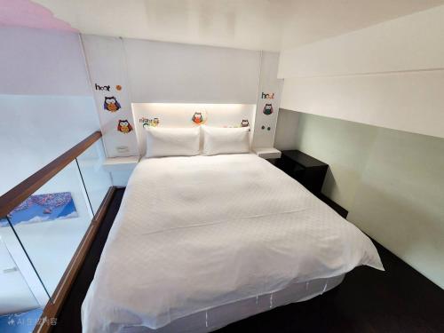 a large white bed in a small room at 湯韻溫泉 in Jiaoxi