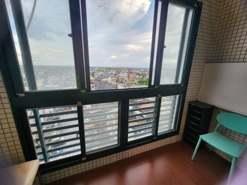 a room with four windows and a blue chair at 湯韻溫泉 in Jiaoxi