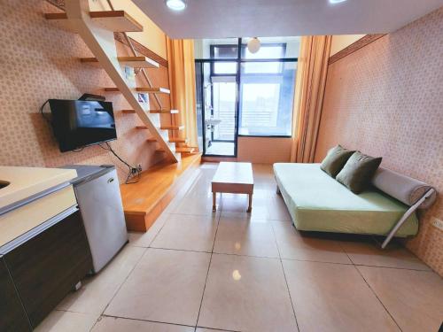 a small living room with a couch and a tv at 湯韻溫泉 in Jiaoxi