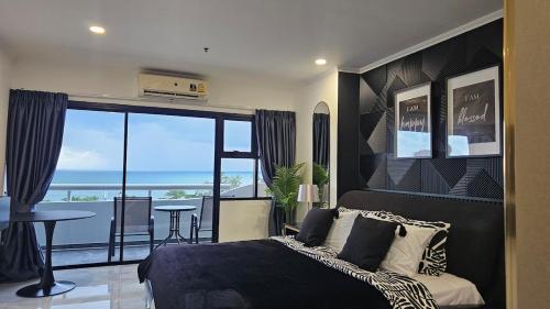 a bedroom with a bed and a view of the ocean at Patong Tower 2 Bedroom Sea View in Patong Beach