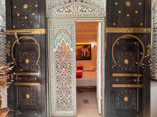 a room with two doors and a bedroom with a bed at Riad Mogador in Meknès