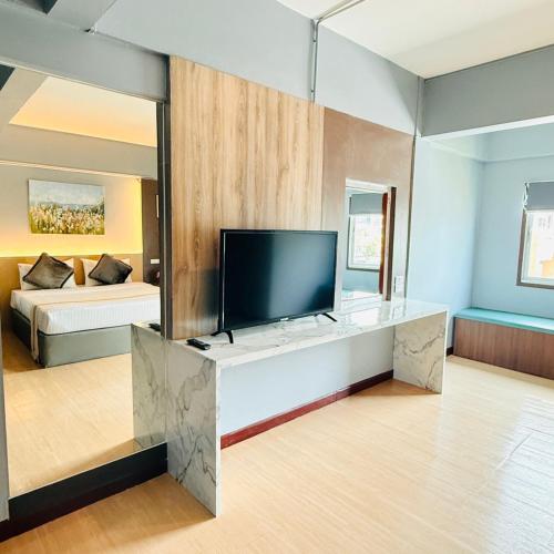 a large living room with a television and a bed at Best LD Hotel โรงแรมเบส แอลดี in Hua Hin