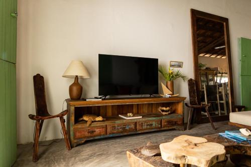 a living room with a flat screen tv on a entertainment center at Casa Mangará in Cruz