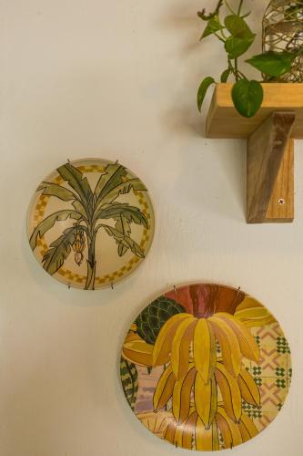 three plates on a wall with a plant on a shelf at Casa Mangará in Cruz