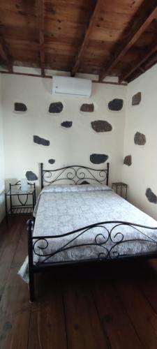 a bedroom with a bed with rocks on the wall at "VILLA SERVANDA" - Casa Canaria construida a PRINCIPIOS DEL SIGLO XIX in Puntagorda