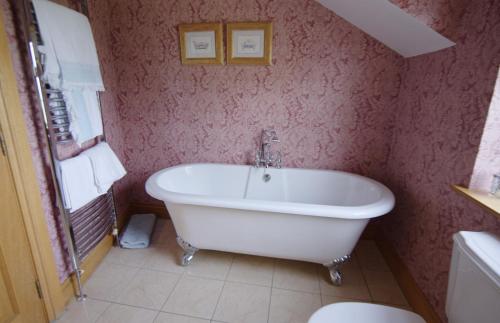a bathroom with a white bath tub and a toilet at Drum Manor in Hillsborough