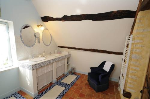 Saint-Germain-des-GroisにあるAu bord de l'Huisneのバスルーム(シンク、青い椅子付)