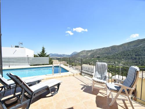 a patio with chairs and a swimming pool and mountains at Peaceful Villa with Private Pool in Adsubia
