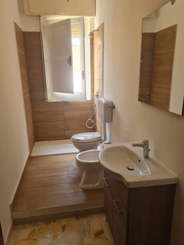 a bathroom with a toilet and a sink and a shower at Casa vacanza Nicla in Rosolini