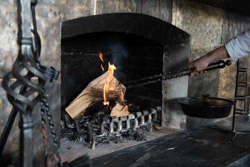 a man is roasting a fire in an oven at Brugger's Genießerhotel Lanersbacherhof in Tux