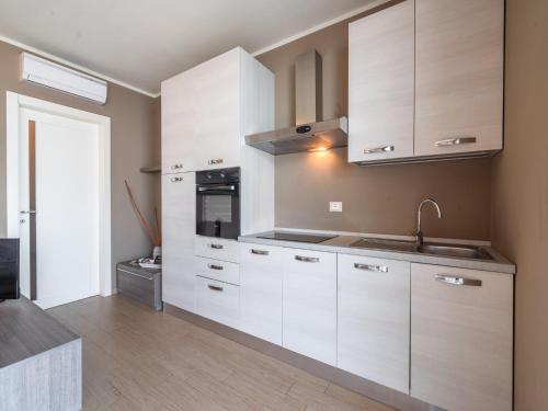a kitchen with white cabinets and a sink at Lakefront Retreat with Garden in Marone