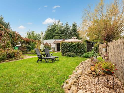 a garden with a bench and a table in the grass at Cozy Stuer Nature Escape in Stuer