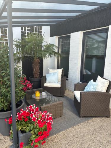 a patio with two chairs and a table and flowers at Casa Wimmer in Allendorf an der Lumda
