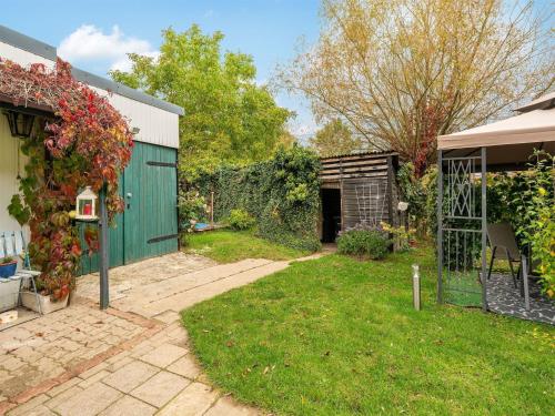 a backyard with a green gate and a yard at Cozy Stuer Nature Escape in Stuer
