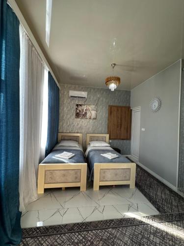 a bedroom with two beds and a window at Chelo Guest House in Kutaisi