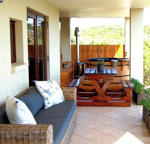 a patio with a couch and a table and a grill at 3onPacific in Sedgefield