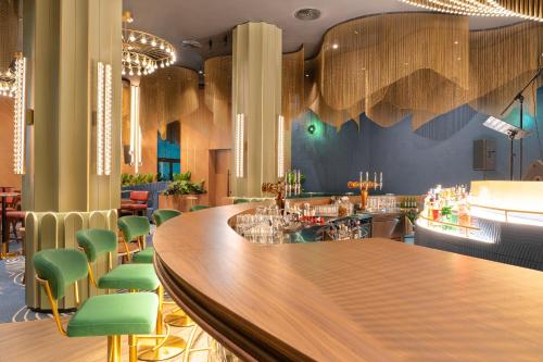 a bar in a restaurant with green chairs at Novotel World Trade Centre Dubai in Dubai
