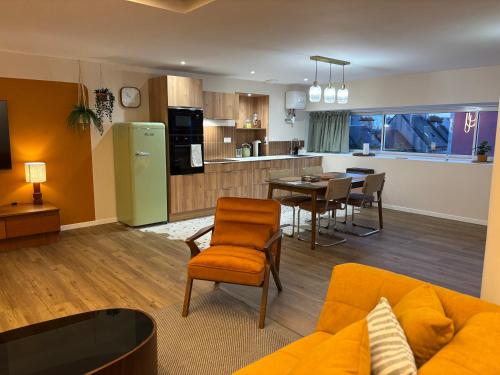 a living room and kitchen with a couch and a table at Cozy Loft tout équipé au cœur de Saint-Lô in Saint Lo