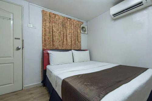 a small bedroom with a bed and a window at Persona Boutique Hotel in Malacca