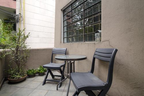 two chairs and a table on a patio at Senda Stays Condesa in Mexico City