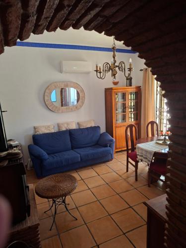 a living room with a blue couch and a table at A Casa da avó Custodinha in Bias do Norte