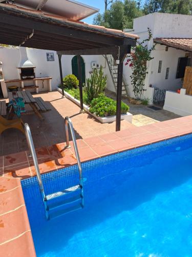 a swimming pool with a table and a house at A Casa da avó Custodinha in Bias do Norte