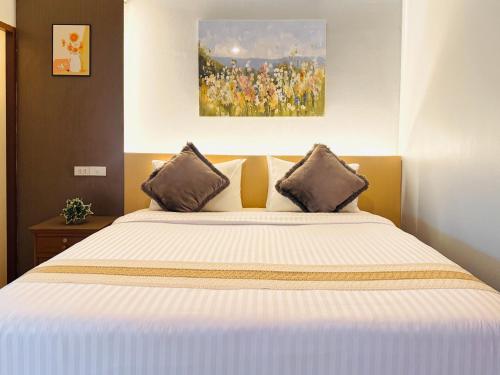 a bedroom with a large white bed with two pillows at Best LD Hotel โรงแรมเบส แอลดี in Hua Hin