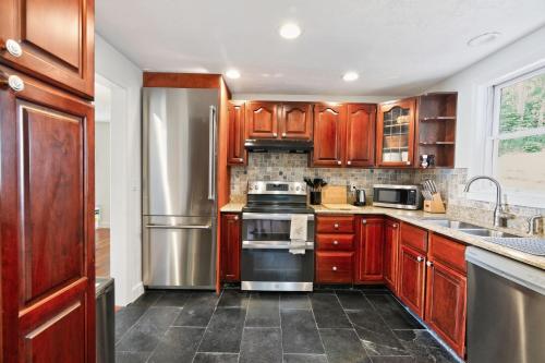 a kitchen with wooden cabinets and a stainless steel refrigerator at Ocean Views & Private Beach 3BR Nature Escape villa in Nameloc Heights