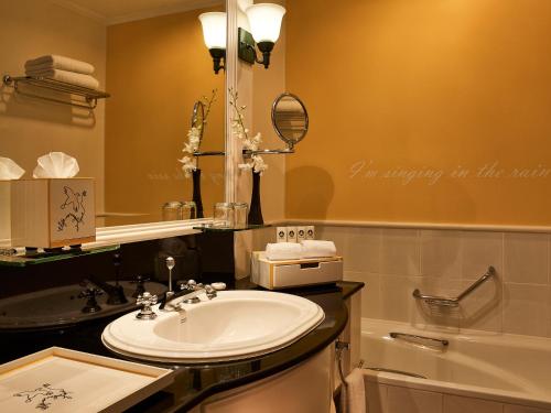 a bathroom with a sink and a mirror and a tub at Sofitel Angkor Phokeethra Golf & Spa Resort in Siem Reap