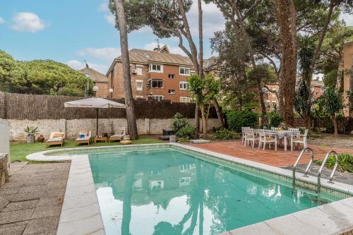 a swimming pool in a yard with a table and chairs at Canela Homes COSTA CA NOSTRA in Gavà