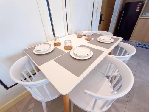 a white table with white chairs and plates on it at Imperio Residence Melaka by Jeffery Lam Home Management in Melaka