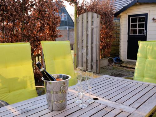 Un cubo con botellas de vino y copas sobre una mesa. en Holiday Home Noordwijk near the Beach, en Noordwijkerhout